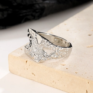 Macro shot of silver lava textured wide ring with hollow details on beige stone