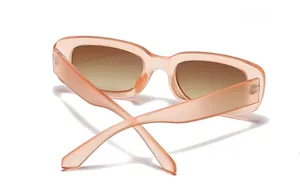 Detail of orange translucent cat-eye sunglasses with wide temples and brown lenses