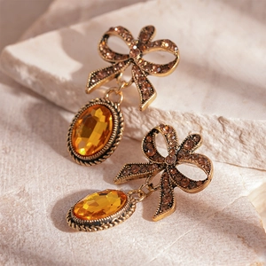 Elegant bow knot earrings with amber oval crystal stones and gold plated metal
