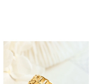 Detailed macro view of 18k gold-plated hollow Cuban chain link ring on white petals