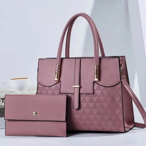 Detail of pink textured leather handbag set with gold hardware and shoulder strap