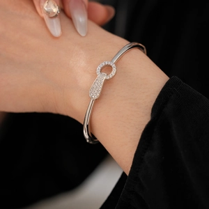 Close-up of silver-plated horseshoe bangle with pavé zircons on a model's wrist
