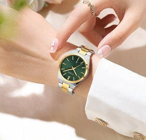 Close-up of a ladies' Curren quartz watch with green dial and silver-gold metal strap