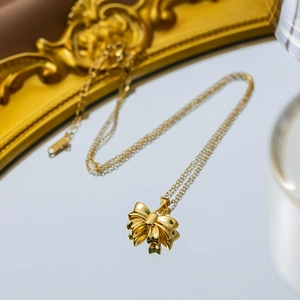 Elegant gold bow pendant necklace with polished finish and delicate link chain for women