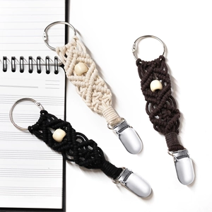 Macro detail of braided cotton hat clips with wooden beads and silver metal fasteners