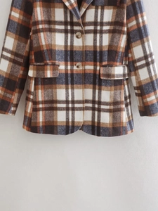 Close-up of double-breasted plaid blazer showing orange and brown tweed texture