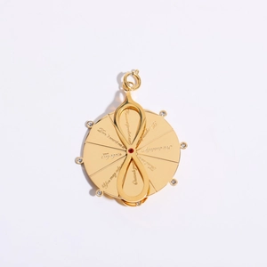 Gold mystic oracle pendant with infinity sign and red gemstone on white background