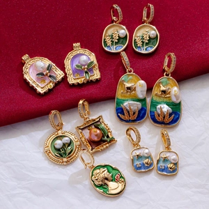 Macro detail of vintage gold enamel pendants with pearls and retro floral motifs