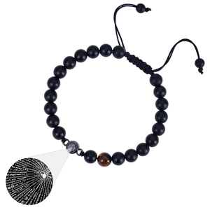 Close-up of matte black beads with tiger eye stone and 100 languages projection charm