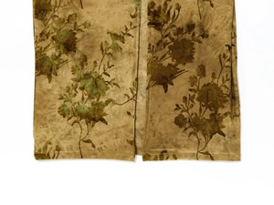 Détail de la robe en tulle transparent avec motifs floraux floqués marron doré