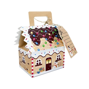 Macro view of gingerbread house shape gift box made of kraft paper with a festive tag