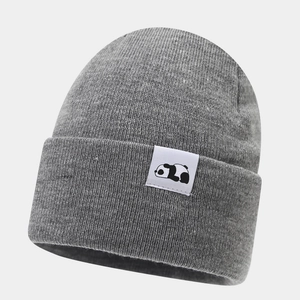 Close-up of a grey knit beanie featuring a minimalist white panda patch detail