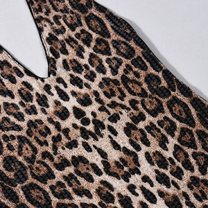 Détail de la robe léopard avec des sequins noirs brillants sur un tissu en maille