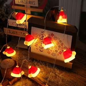 Festive Christmas hat LED string lights with warm yellow glow on a cozy wooden background