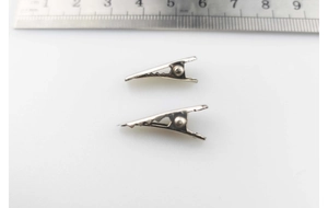 Macro shot of 2cm silver metal mini hair clips with ruler showing precise sizing