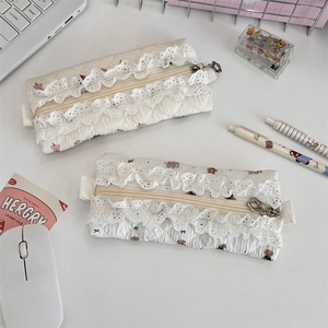 Detailed close-up of quilted floral lace pencil cases with cute bear patterns and zippers