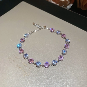 Detail of a silver bracelet featuring sparkling pink and light blue round-cut stones