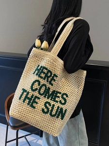 Minimalist straw woven tote bag with 'Here Comes the Sun' text and hollow mesh design
