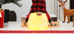 Detail of LED glowing Christmas gnome featuring red black plaid hat and warm fiber beard