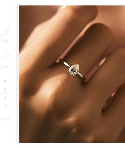 Macro detail of a 1-carat pear-cut moissanite silver ring worn on a finger