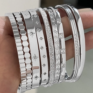 Assortment of silver stainless steel bracelets with starburst and pavé diamond designs