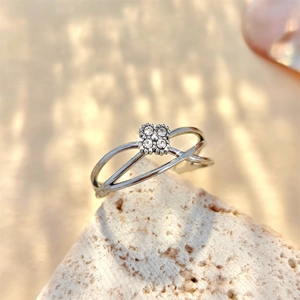 Detailed view of silver interlocking ring band featuring central zircon floral pattern