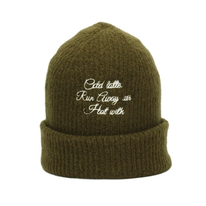 Detailed texture of olive green knit beanie with white letter embroidery on the front