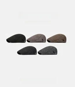 Detail of herringbone pattern texture and adjustable metal buckle on newsboy caps