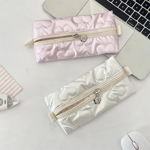 Detailed view of heart-quilted stationery pouch with floral metal zipper pull detail