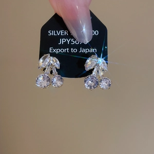 Macro shot of S925 silver cherry earrings with sparkling zircon leaves and fruit stones