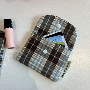 Detail of plaid fabric card holder with snap closure and multi-card slot organization