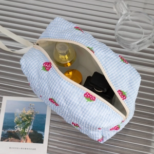 Détail de la trousse de maquillage matelassée aux fraises avec zoom sur les coutures