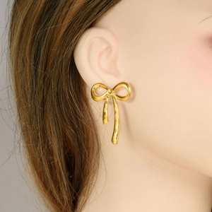 Elegant 18k gold plated stainless steel bow stud earrings shown on model side view