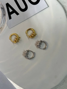 Detail of twisted S925 sterling silver hoop earrings in gold and silver finish