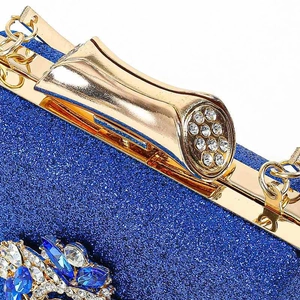 Detail van de donkerblauwe glitter avondtas met gouden sluiting en kristallen sieraad
