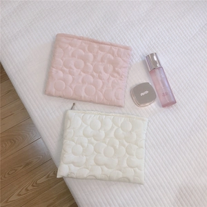 Detailed macro view of floral quilted soft down puffer bags in pink and cream beige