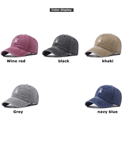 Detail showing various colors of washed cotton baseball caps with spider embroidery