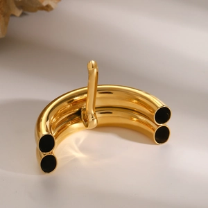 Close-up of polished gold stainless steel hair pin with modern curved double-tube design