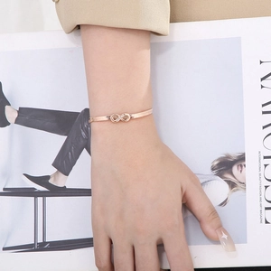 Detailed view of rose gold infinity bracelet with micro-pave crystals on wrist
