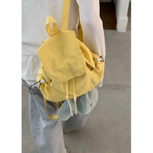 Detail of yellow bowling shoulder bag with drawstring closure and flap cover