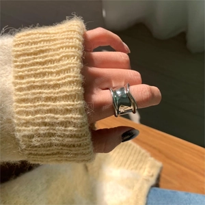 Close-up of minimalist 925 silver wide ring with irregular concave design on hand
