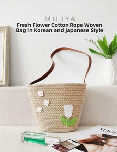 Detail of woven cotton rope handbag featuring handmade crochet flowers and leather strap
