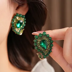 Vintage style emerald leaf drop earrings with retro baroque gold finish and green crystals