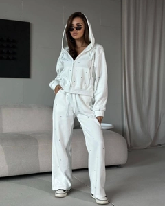 Detailaufnahme des weißen Kapuzenanzugs mit silbernem Strassbesatz für einen modischen Look
