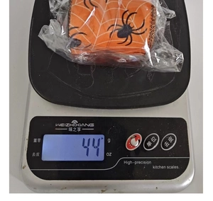 Detailed view of Halloween orange spider web ribbon roll weighing 44g for DIY party decor