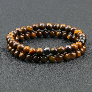Detail of double-layer tiger eye stone beaded bracelets with a metallic hexagon bead accent
