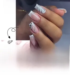 Détail de faux ongles français avec motifs zébrés et strass sur base rose pâle