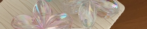 Detailed view of colorful iridescent flower hair claws with translucent petal texture