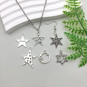 Flat lay of antique silver alloy star pendants and jewelry charms with dream engraving