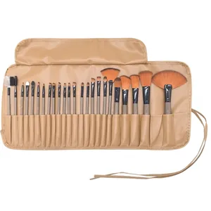 Detailed top view of a 24-piece professional makeup brush set with tan leather wrap case